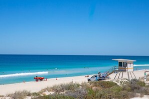 A lifeguard tower, beach, and ocean.