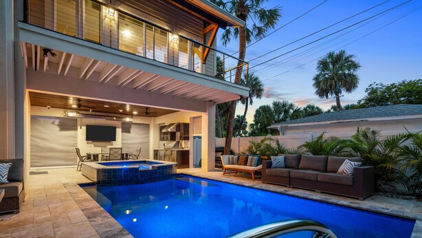 A modern outdoor pool area with a hot tub, seating, and a covered patio. - A Sunset Dream - Monthly Beach Rental (Clearwater Beach)