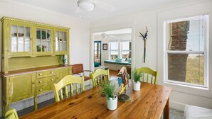 A dining area with a wooden table, yellow chairs, and a green cabinet.