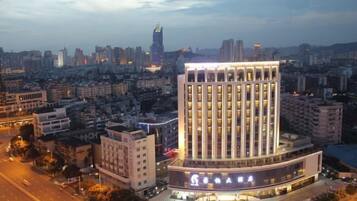 A modern hotel with a prominent central tower, surrounded by a cityscape.