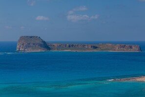 A coastal landscape with a prominent cliff and a small island. - History and Charm in Old Town Chania (Chania)