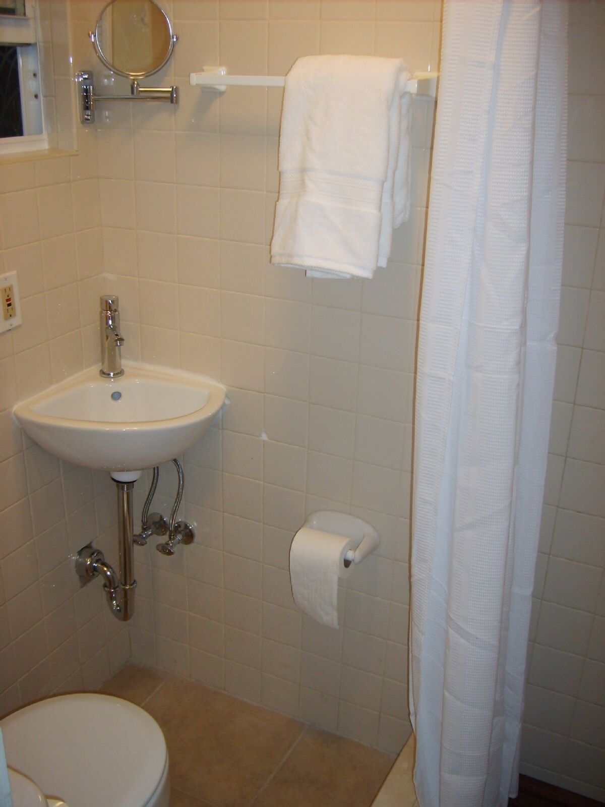 Een badkamer met een wastafel, toilet en handdoekrek.