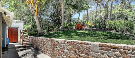 A stone wall with a tiled pathway leading to a wooden door.