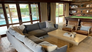 A living room with a sectional sofa, a coffee table, and a pool table. - Langbrook Estate Cottage (Yarra Junction)