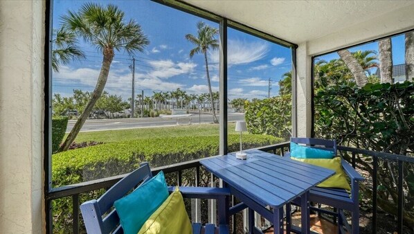 A room with a large window, a table, and two chairs.