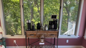 A wooden desk with a coffee maker, a kettle, and a sign reading 'Coffee' against a backdrop of a window with a view of trees. - Steps to Cliff House Resort, Minutes to Perkins Cove and Ogunquit.  (York)