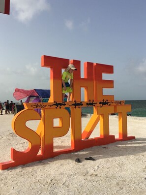 A large outdoor sign with the text "THE SPLIT" on a beach.