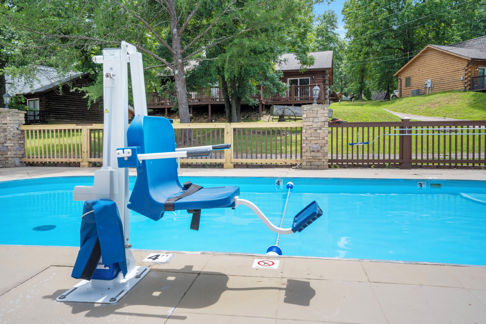 Une piscine avec une chaise bleue et un poste de surveillance pour les sauveteurs.