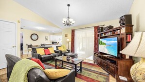 A living room with a sofa, coffee table, TV, and a patterned rug.