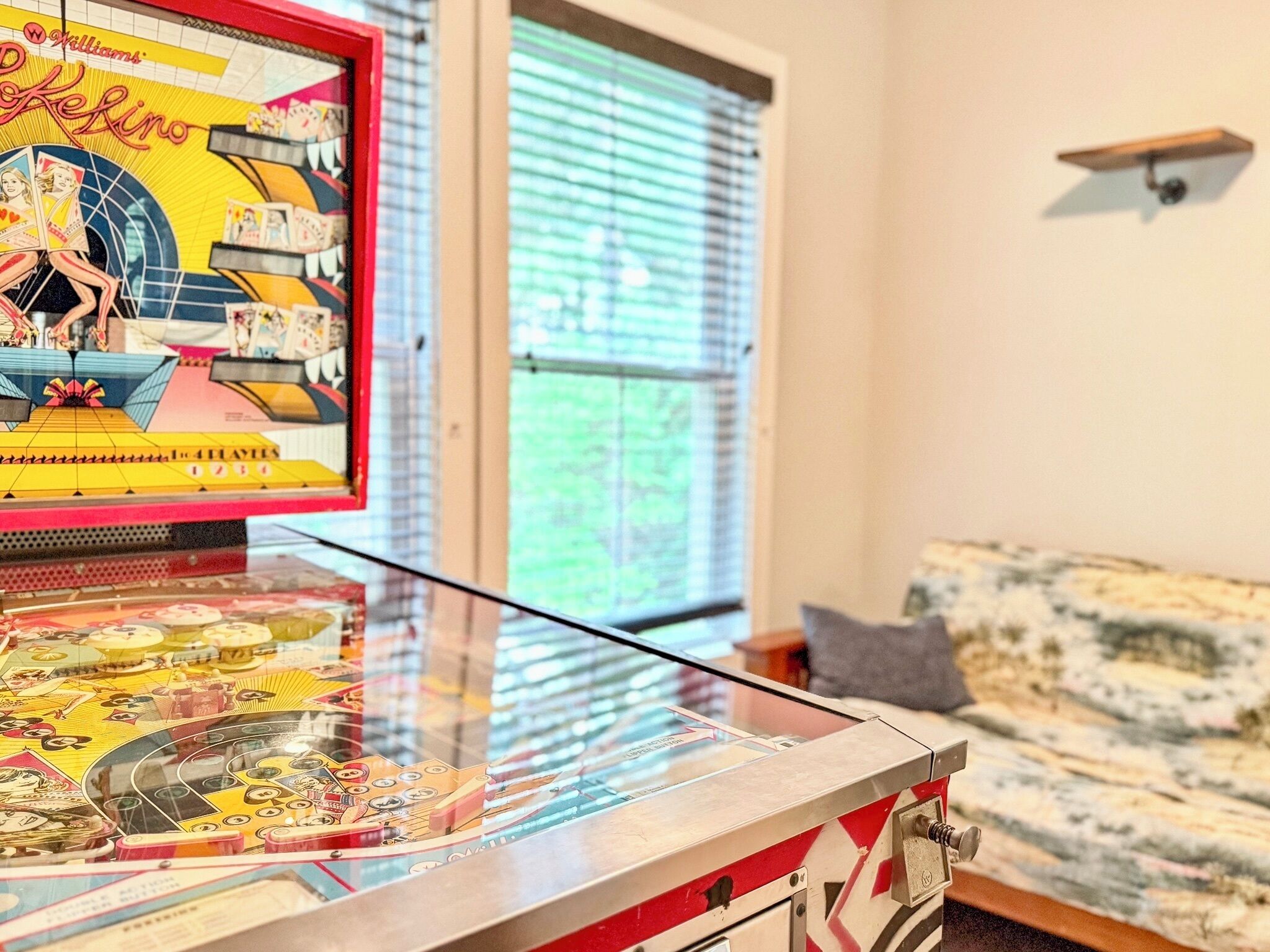 A pinball machine with a colorful design and a window in the background.