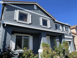 A two-story house with a dark blue exterior, white trim, and multiple windows with shutters. - MODERN NEWER HOME CLOSE TO NAPA WINE COUNTRY, SACRAMENTO &  SAN FRANCISCO (FAIRFIELD)
