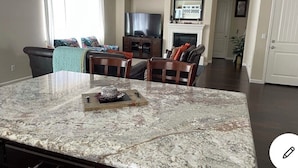 A spacious living area with a large marble island, a fireplace, and a television. - MODERN NEWER HOME CLOSE TO NAPA WINE COUNTRY, SACRAMENTO &  SAN FRANCISCO (FAIRFIELD)