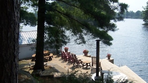 A wooden deck with outdoor furniture overlooking a lake.