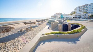 A beachside hotel with a pool, lounge chairs, and a view of the ocean. - Villa 5 – Newly Remodeled Oceanfront Luxury Villa (Puerto Peñasco)