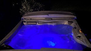 Un bain à remous doté d’un système d’éclairage bleu, situé dans un environnement sombre.