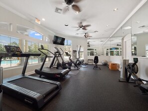 A gym with treadmills, exercise bikes, and a mirrored wall. - Your perfect stay starts here. Near Disney/Universal. (Kissimmee)