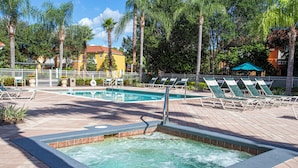 A pool area with a hot tub, lounge chairs, and a fenced pool. - Your perfect stay starts here. Near Disney/Universal. (Kissimmee)