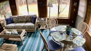 Una habitación acogedora con suelo a rayas, un sofá, una mesa de comedor con sillas y una lámpara.