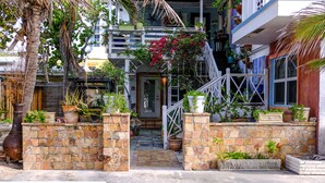 A residential building with a stone entrance, potted plants, and a staircase leading to the upper floors. - Located steps from the ocean, offering true beach living (Hollywood)