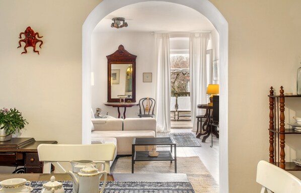 Relax in this stylish living room with a sofa set, coffee table, and dining area, plus a balcony with a view.