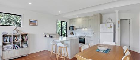 A modern kitchen with white cabinets, a built-in oven, and a refrigerator.