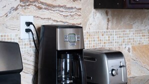 A kitchen with a coffee maker, toaster, and stove. - Updated Quiet and Comfortable Uptown 1br Apt (New Orleans)