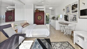 Une chambre à coucher moderne, dotée d’un grand lit, d’un bureau et offrant une vue sur l’extérieur.