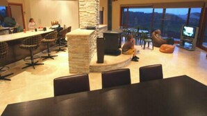 A spacious living area with a stone pillar, a bar, and a large window offering a view. - Almonta Park Lodge (Coffin Bay)