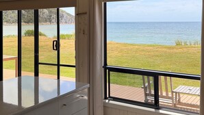 A room with a large window, a white dresser, and a view of the sea. - Sandy Shores on Irby - Beach frontage at beautiful Sisters Beach (Sisters Beach)