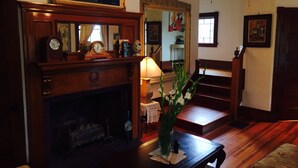 Ein traditionell eingerichtetes Wohnzimmer mit Kamin, Holzmöbeln und einer Treppe.