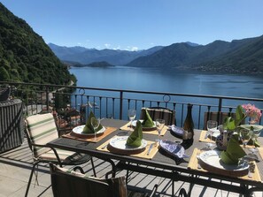 A table set for dining with a view of a lake and mountains.