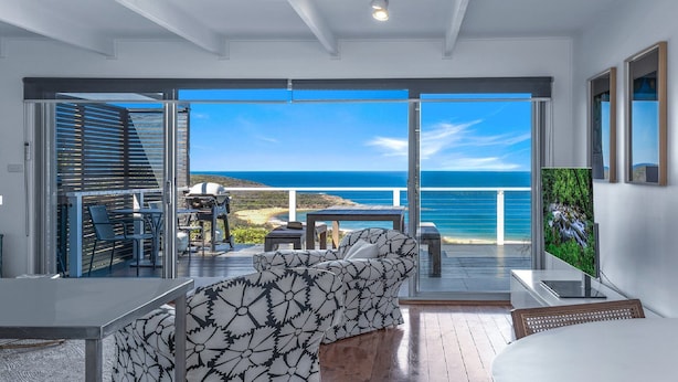 A modern balcony with a view of the ocean, furnished with a sofa, chairs, and a grill. - 33 Degrees - Stunning Views by HolidayCo. (KILLCARE HEIGHTS)