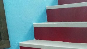 Eine Treppe in Rot und Weiß vor einer blauen Wand.