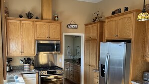 A modern kitchen with wooden cabinets, stainless steel appliances, and granite countertops.