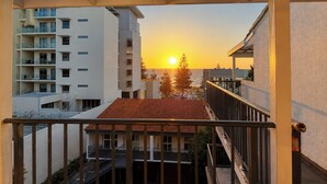 A balcony with a view of a sunset, buildings in the background, and a clear sky. - West Beach Lagoon 123 - Location &amp; Views!!! (Scarborough)
