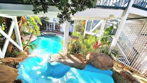 A swimming pool with a rock-lined edge, surrounded by a white fence and greenery. - West Beach Lagoon 123 - Location &amp; Views!!! (Scarborough)