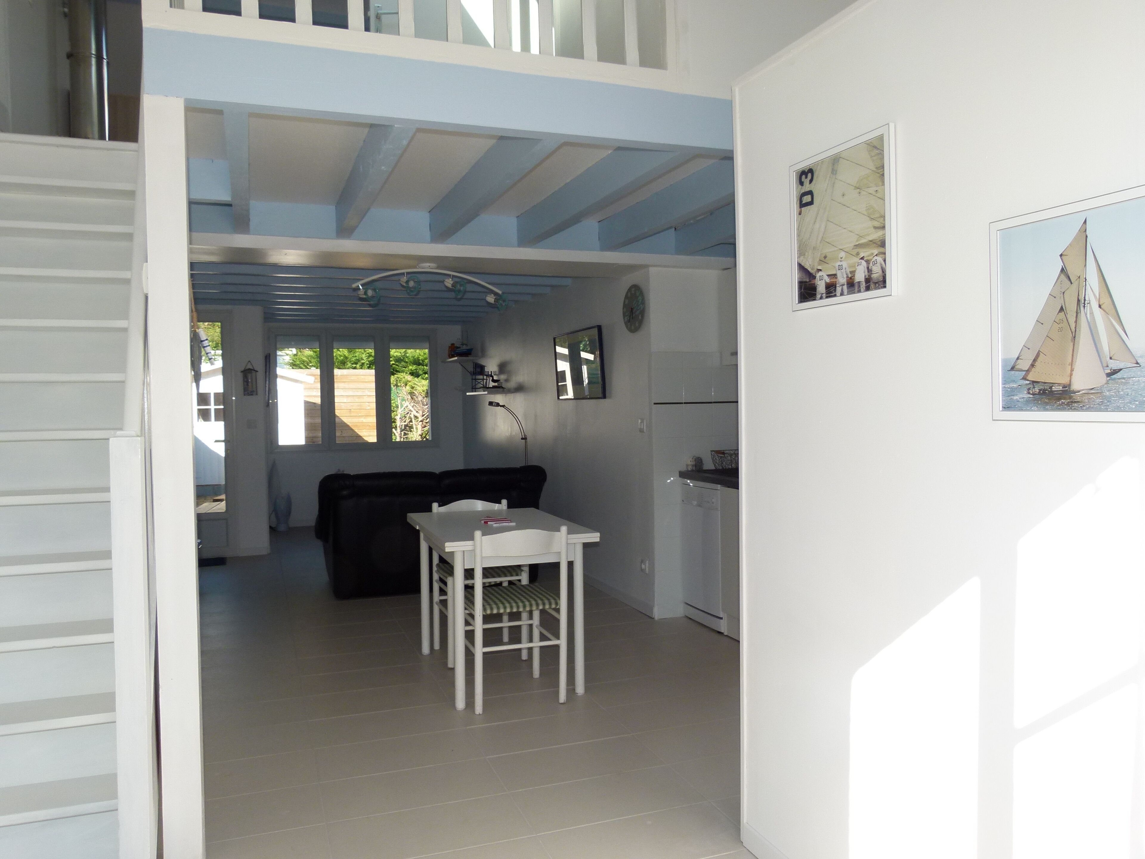 Un ambiente compatto con zona pranzo, divano e angolo cottura.
