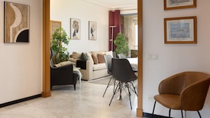 Un salon moderne avec un canapé, des fauteuils et des œuvres d’art accrochées aux murs.
