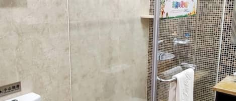 A bathroom with a glass shower enclosure, a toilet, and a towel rack.