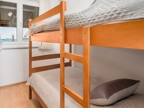 Cama literera con vista al mar a través de una ventana.