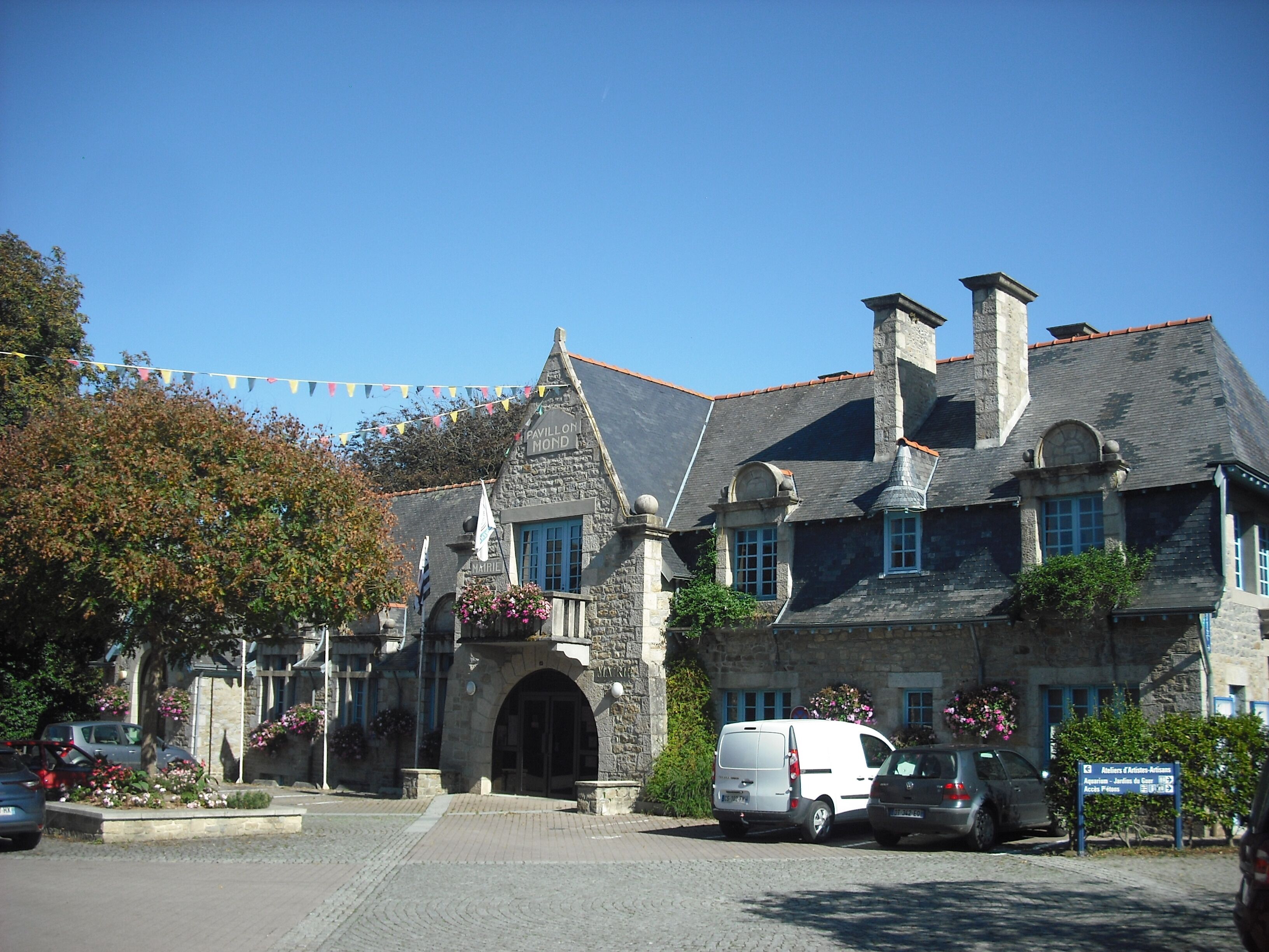 Ein Steinhaus im traditionellen Baustil, mit einem markanten Eingang und mehreren Schornsteinen.