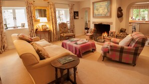 A cozy living room with a fireplace, comfortable seating, and a dining area with a table and chairs.