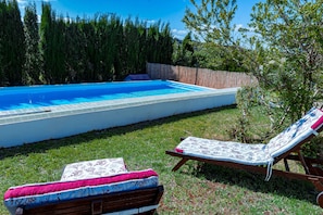 A swimming pool with two lounge chairs and a covered bench. - Welcome to Villa Mirta: Your Tranquil Retreat in Alghero (Alghero)