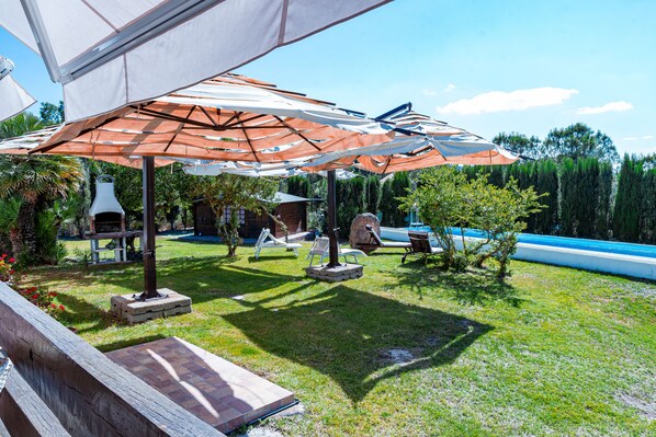 A patio area with outdoor furniture, umbrellas, and a swimming pool. - Welcome to Villa Mirta: Your Tranquil Retreat in Alghero (Alghero)