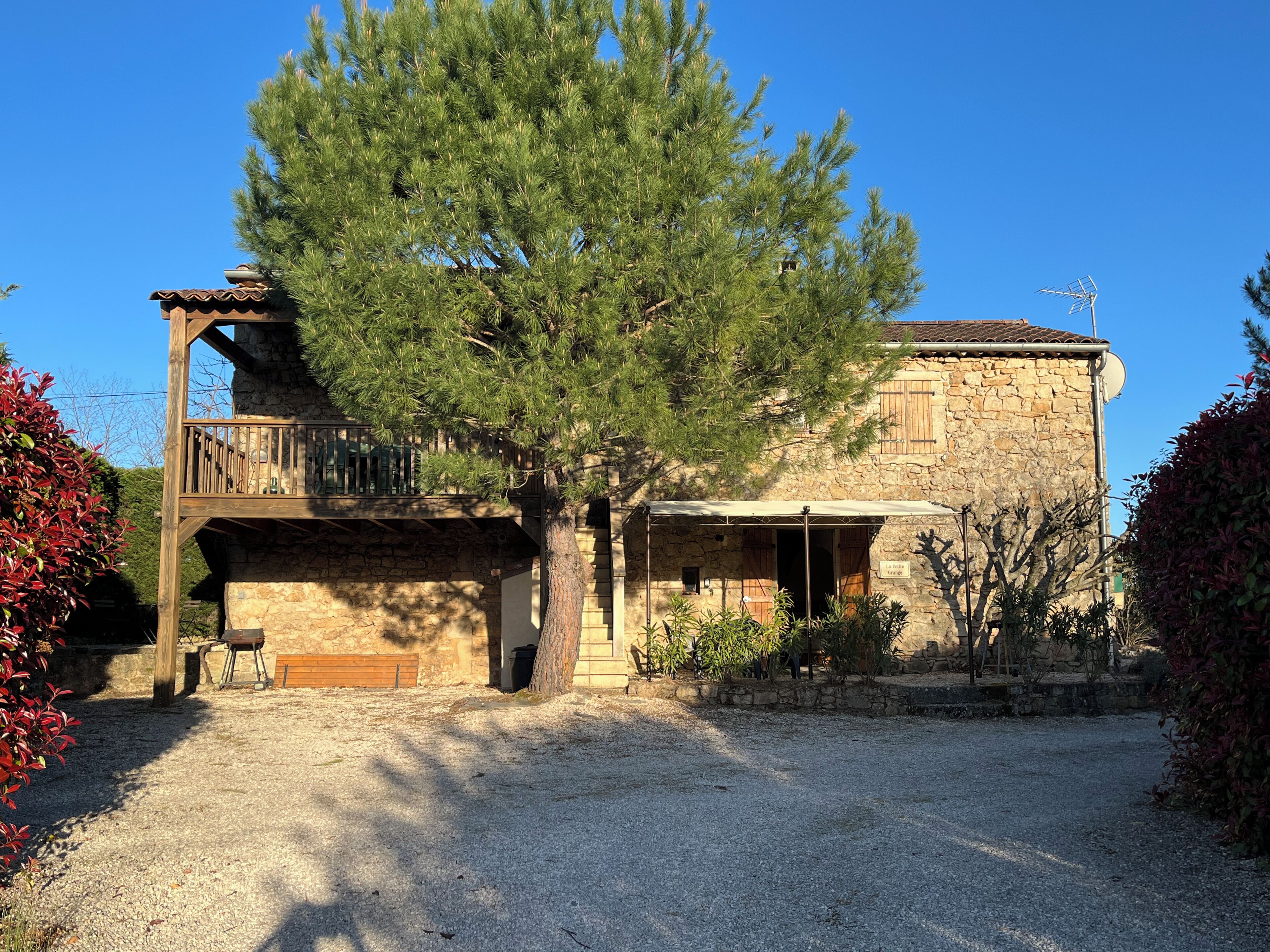 A stone building with a wooden balcony and a covered porch.