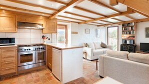 A kitchen with wooden cabinets, a stove, and a refrigerator. - La Magnanerie - Fantastic views, perfect base for the Ardeche and Chazzezac (Lablachère)