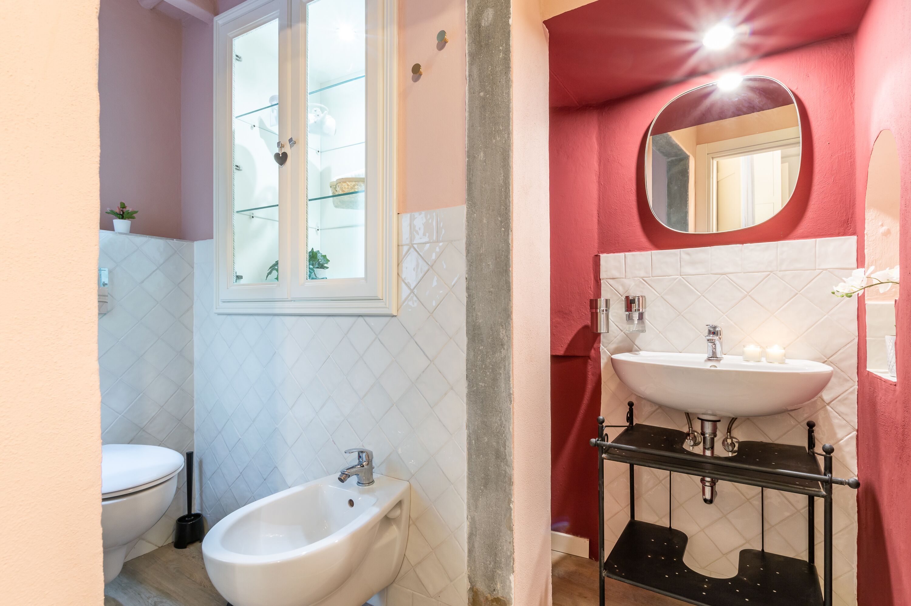 Une salle de bain comprenant des toilettes, un bidet et deux lavabos.