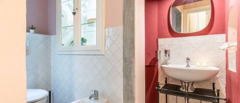 Une salle de bain comprenant des toilettes, un bidet et deux lavabos.