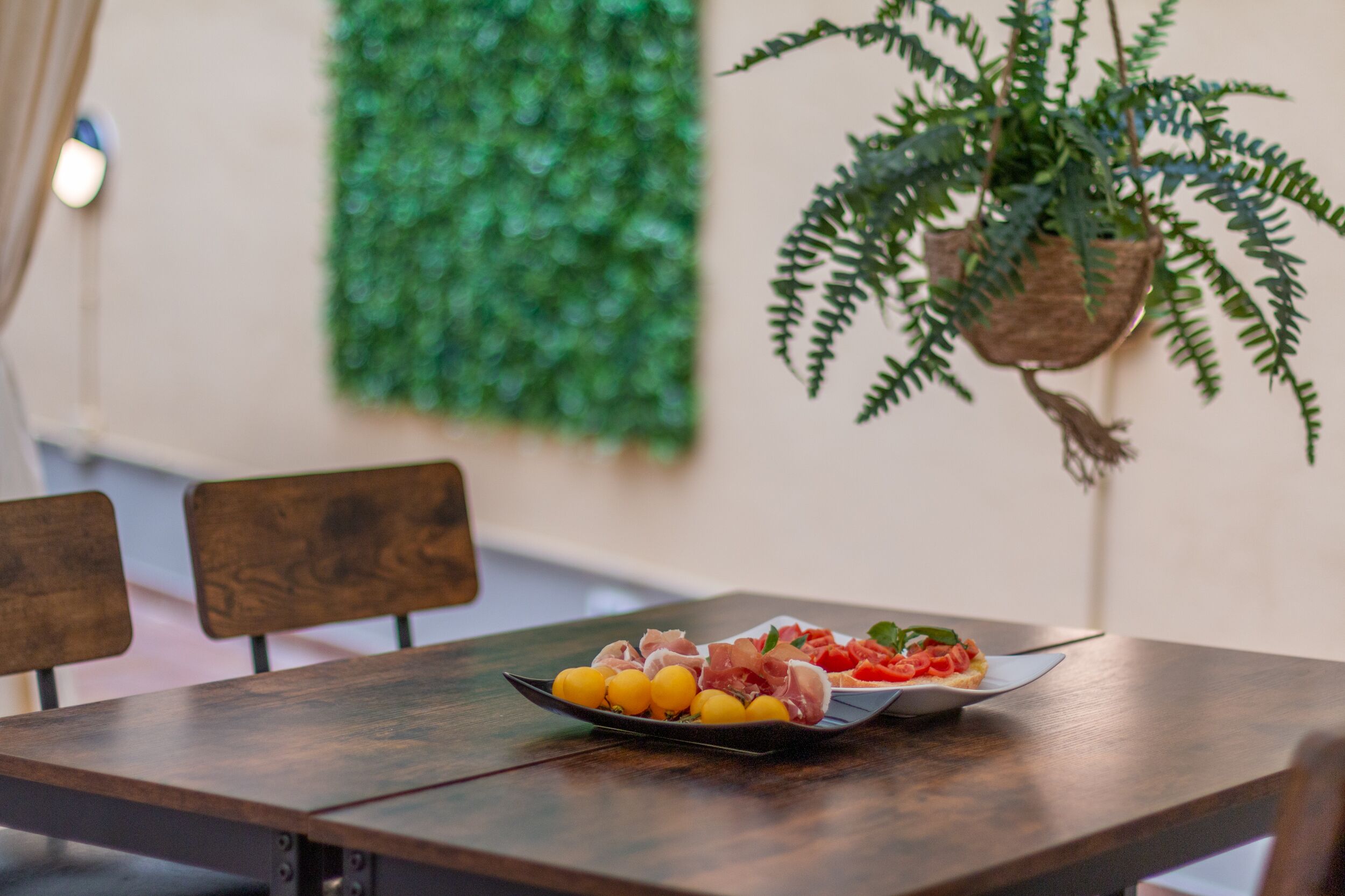 Une table en bois avec une assiette de nourriture et une plante en pot.