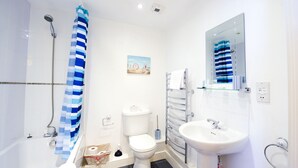 Ein modernes Badezimmer mit Badewanne, Dusche, Toilette und Waschbecken.